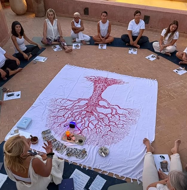 Séance de méditation en cercle dans le patio du Riad Vendôme Marrakech — retraite yoga professeur, tapis bleus, tissu arbre de vie